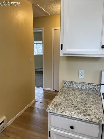 a view of a kitchen with wooden floor and cabinets
