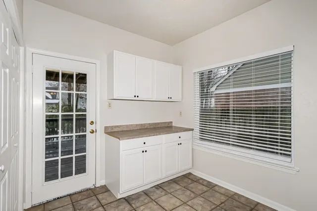 a view of kitchen with granite countertop cabinets and window
