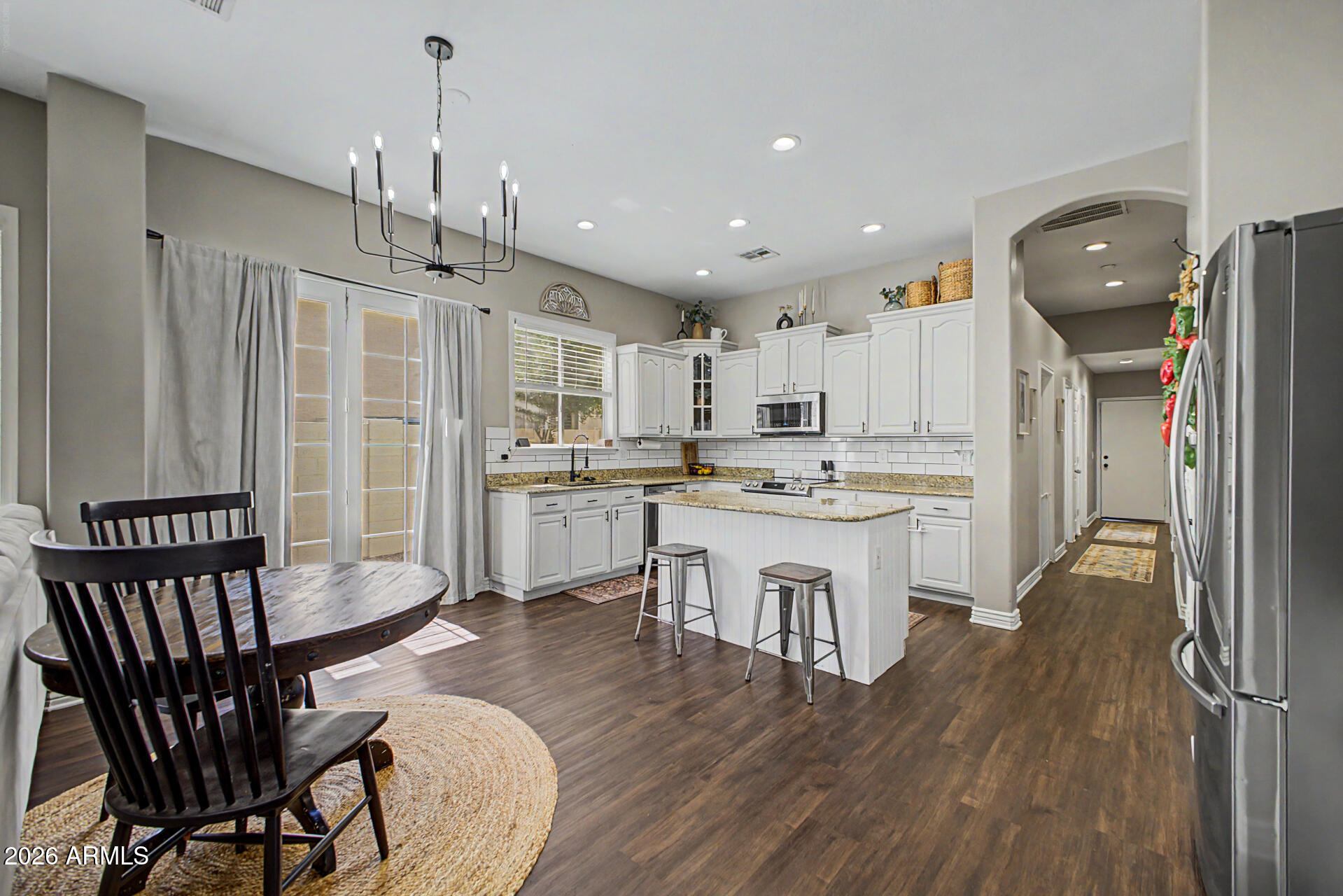 2065 South Porter Street Gilbert, AZ 85295 - Photo 13 of 36 a open kitchen with stainless steel appliances granite countertop a kitchen island hardwood floor sink stove dining table and chairs