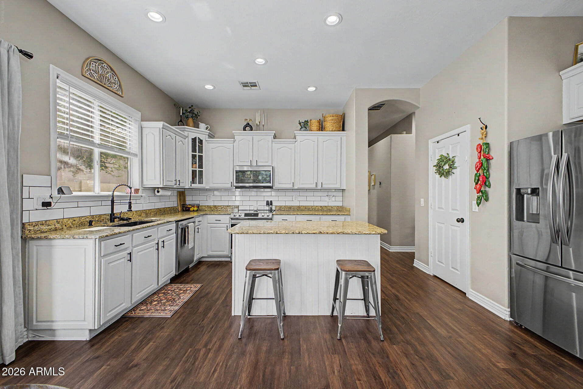 2065 South Porter Street Gilbert, AZ 85295 - Photo 14 of 36 a kitchen with stainless steel appliances a refrigerator a sink dishwasher a stove and white countertops with wooden floor