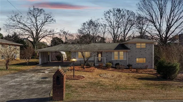 a front view of a house with a yard covered with snow