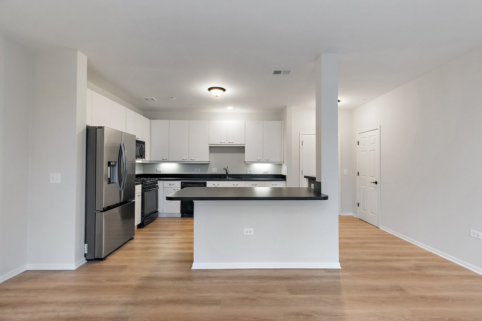 640 McHenry Road, Unit 303 Wheeling, IL 60090 - Photo 4 of 20 a kitchen with stainless steel appliances granite countertop a kitchen island hardwood floor and a sink