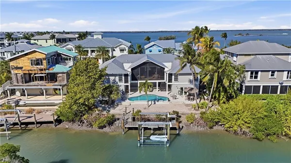 an aerial view of a house with swimming pool and outdoor seating
