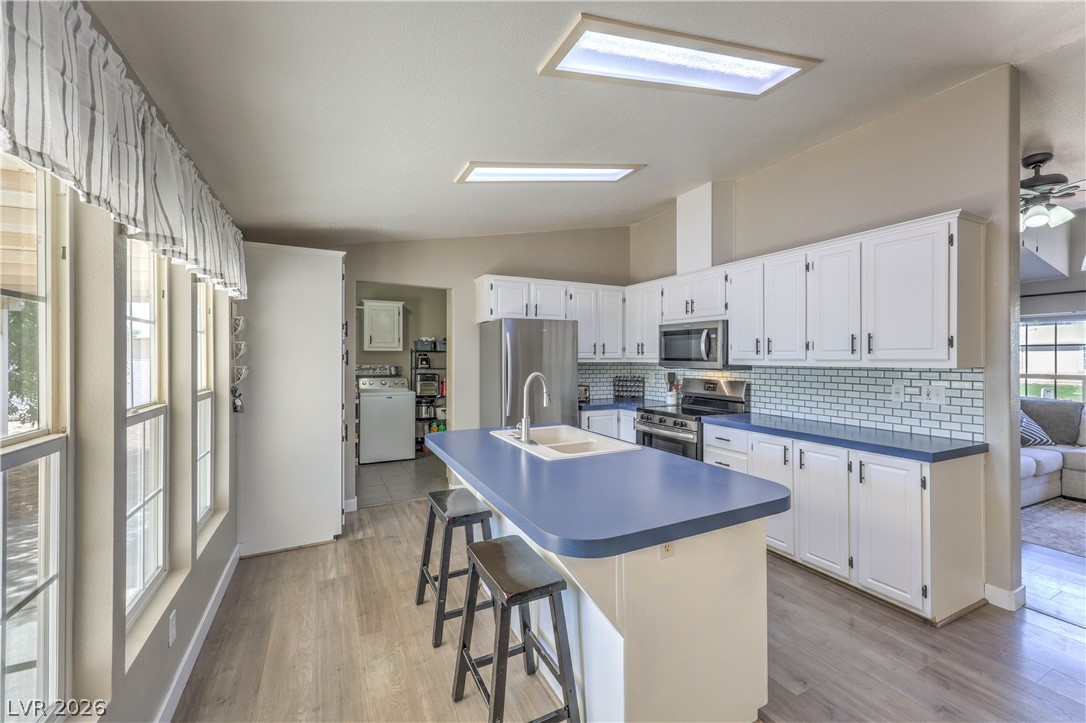 348 Tres Palomas Street Overton, NV 89040 - Photo 14 of 41 A well-lit kitchen presents a blue island and stainless steel appliances.