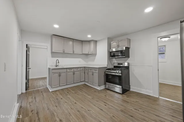 a kitchen with stainless steel appliances and a wooden floor