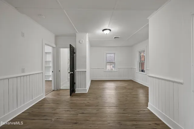 a view of empty room with wooden floor