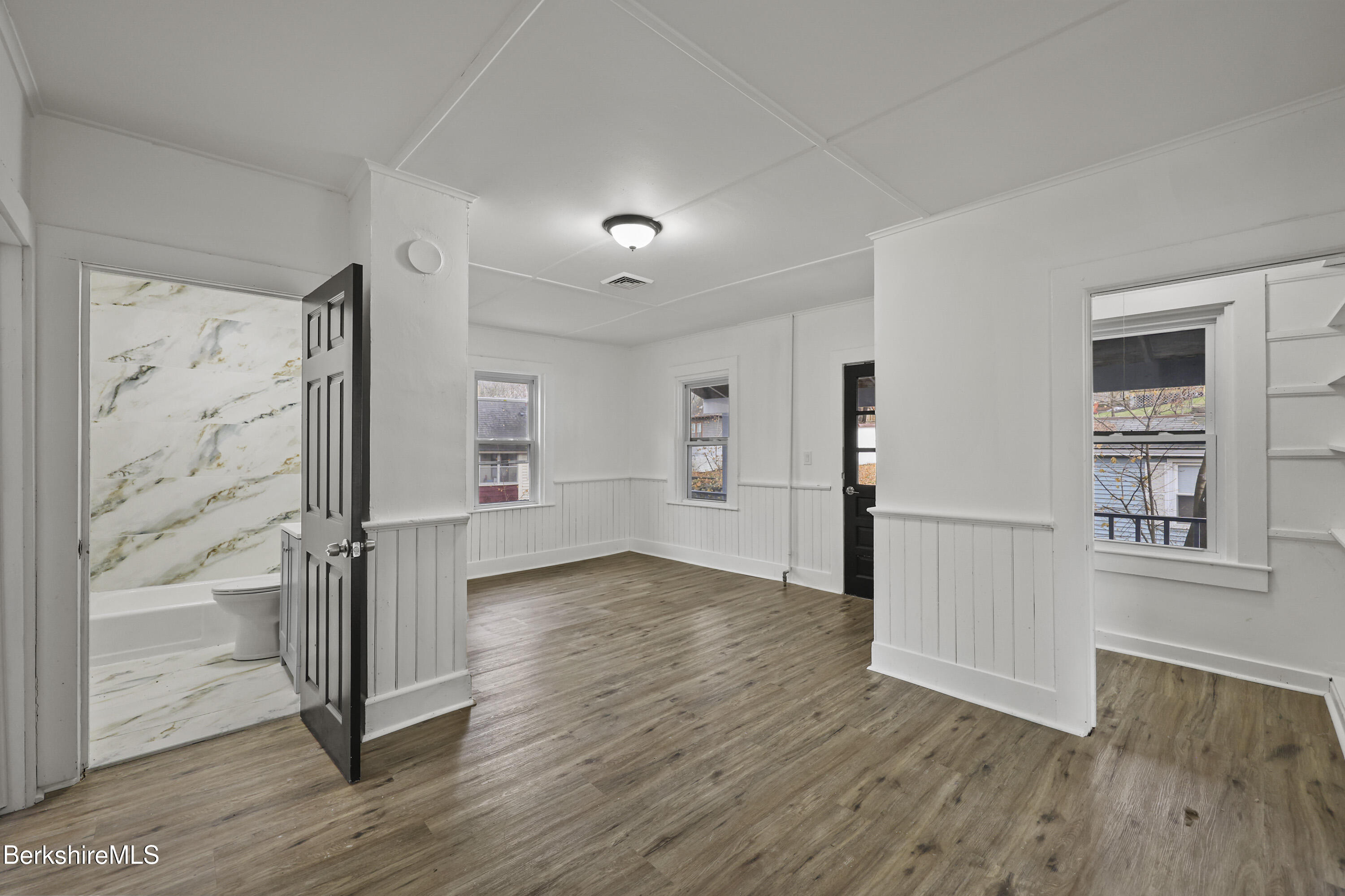 41 Prospect Street North Adams, MA 01247 - Photo 27 of 34 an empty room with wooden floor and a kitchen