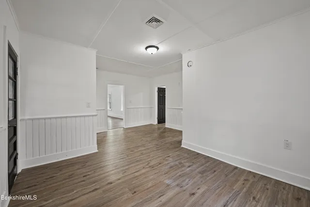 a view of empty room with wooden floor