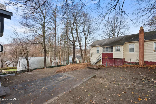 a view of a house with a large tree in front