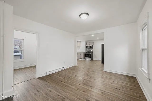 a view of empty room with wooden floor