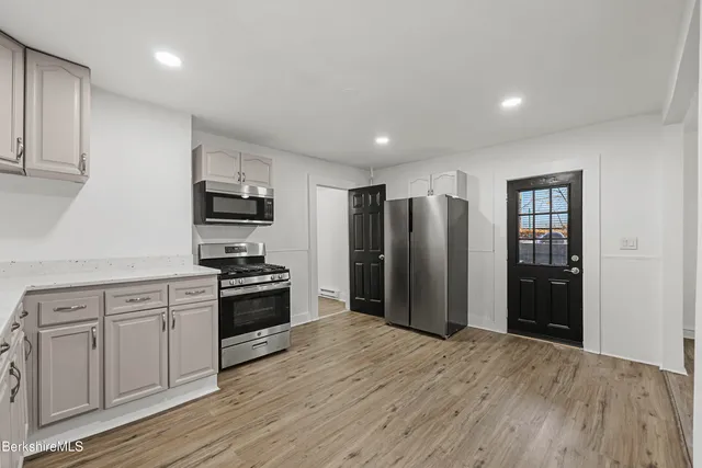 a kitchen with stainless steel appliances granite countertop a refrigerator and a stove top oven
