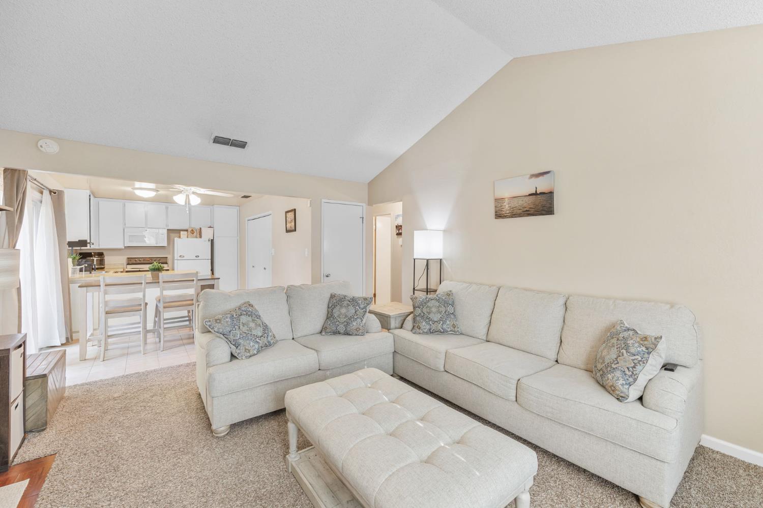 a living room with furniture and kitchen view