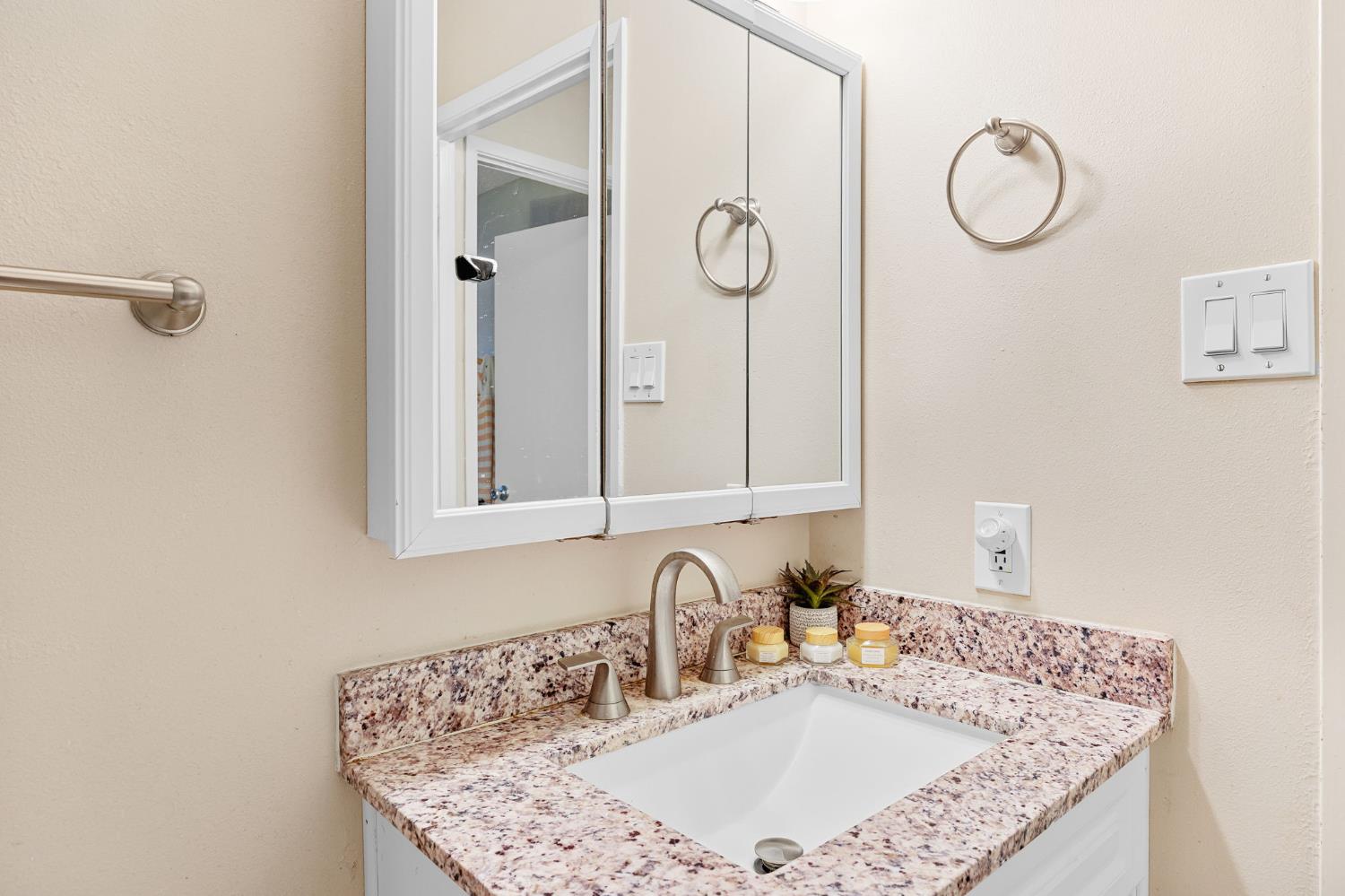 8849 La Riviera Drive, Unit A Sacramento, CA 95826 - Photo 14 of 19 a bathroom with a granite countertop sink and a mirror