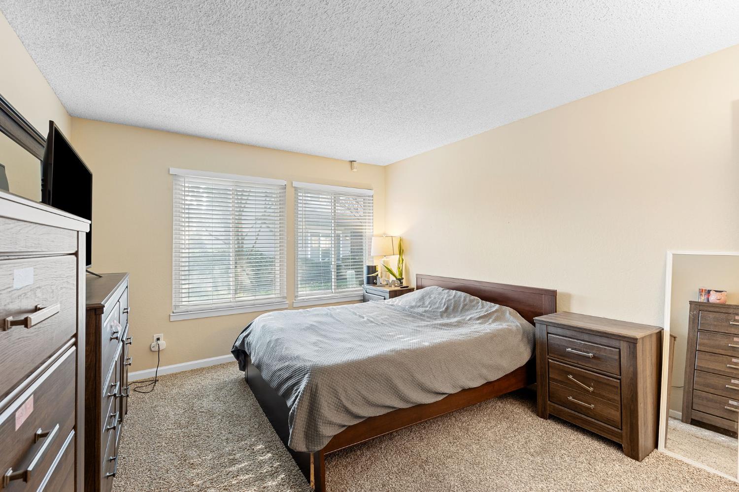8849 La Riviera Drive, Unit A Sacramento, CA 95826 - Photo 16 of 19 a bedroom with a bed dresser and a window