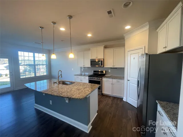 a kitchen with refrigerator cabinets and wooden floor