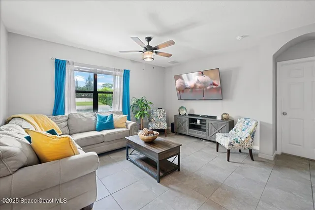 a living room with furniture ceiling fan and a window