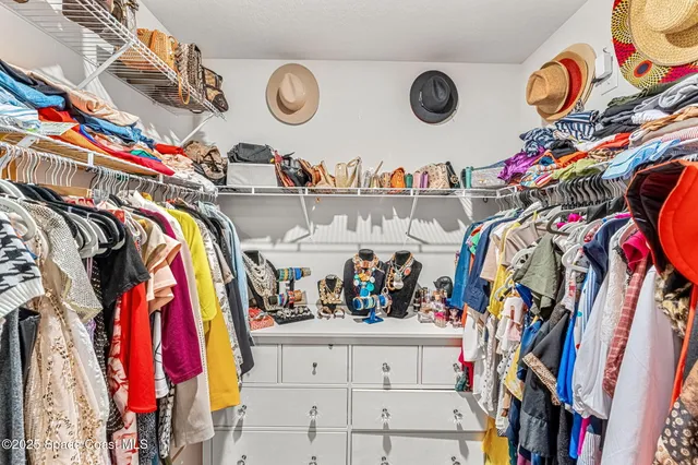 a view of walk in closet with clothes