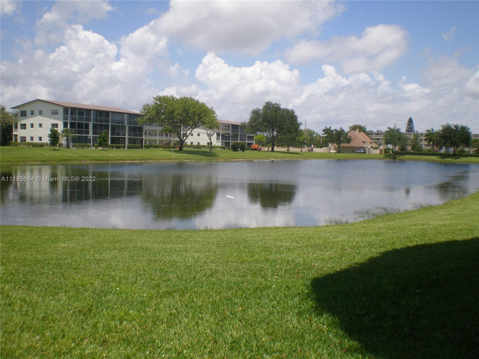 129 Brighton D, Unit 129 Boca Raton, FL 33434 - Photo 19 of 28 a view of a lake with houses in the back