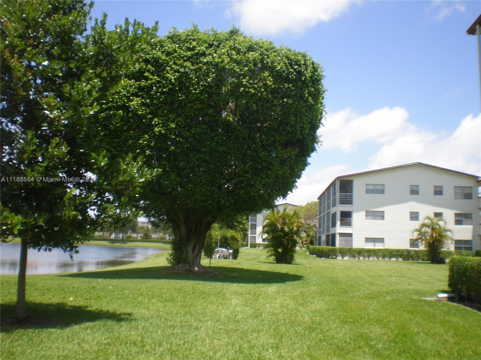 129 Brighton D, Unit 129 Boca Raton, FL 33434 - Photo 20 of 28 a front view of house with yard and green space