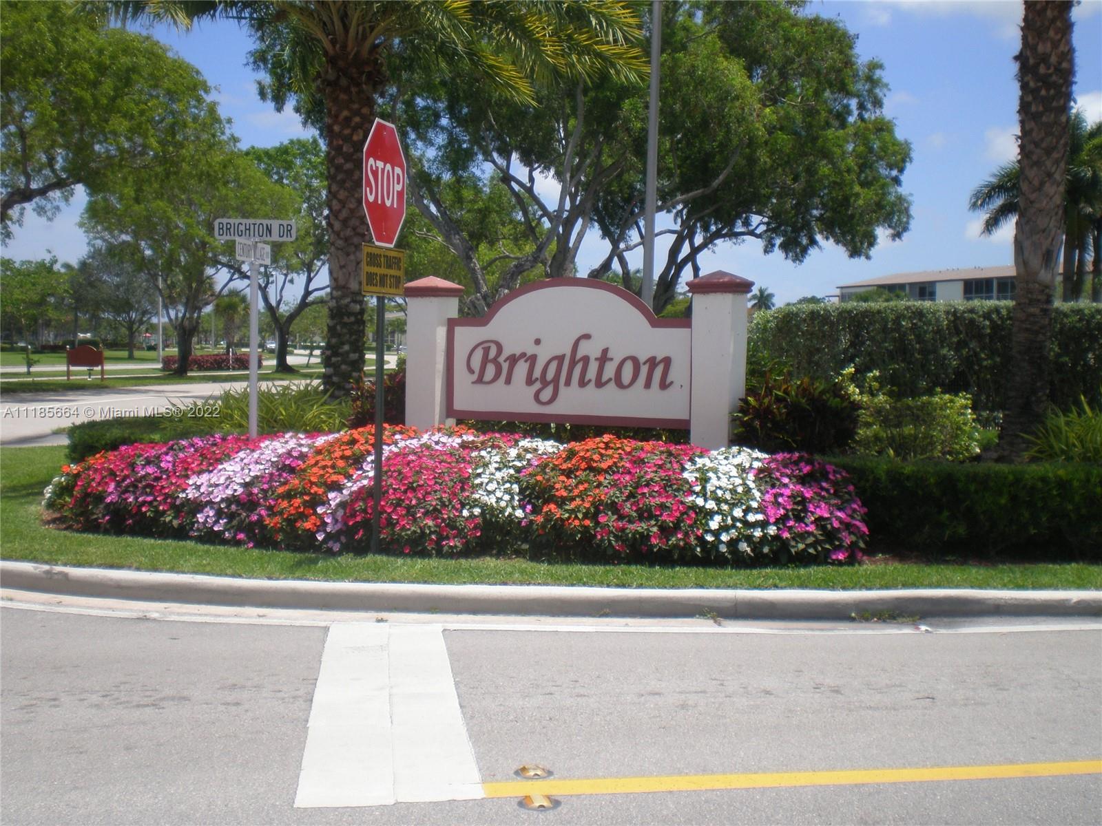 129 Brighton D, Unit 129 Boca Raton, FL 33434 - Photo 21 of 28 a sign that is in front of flowers