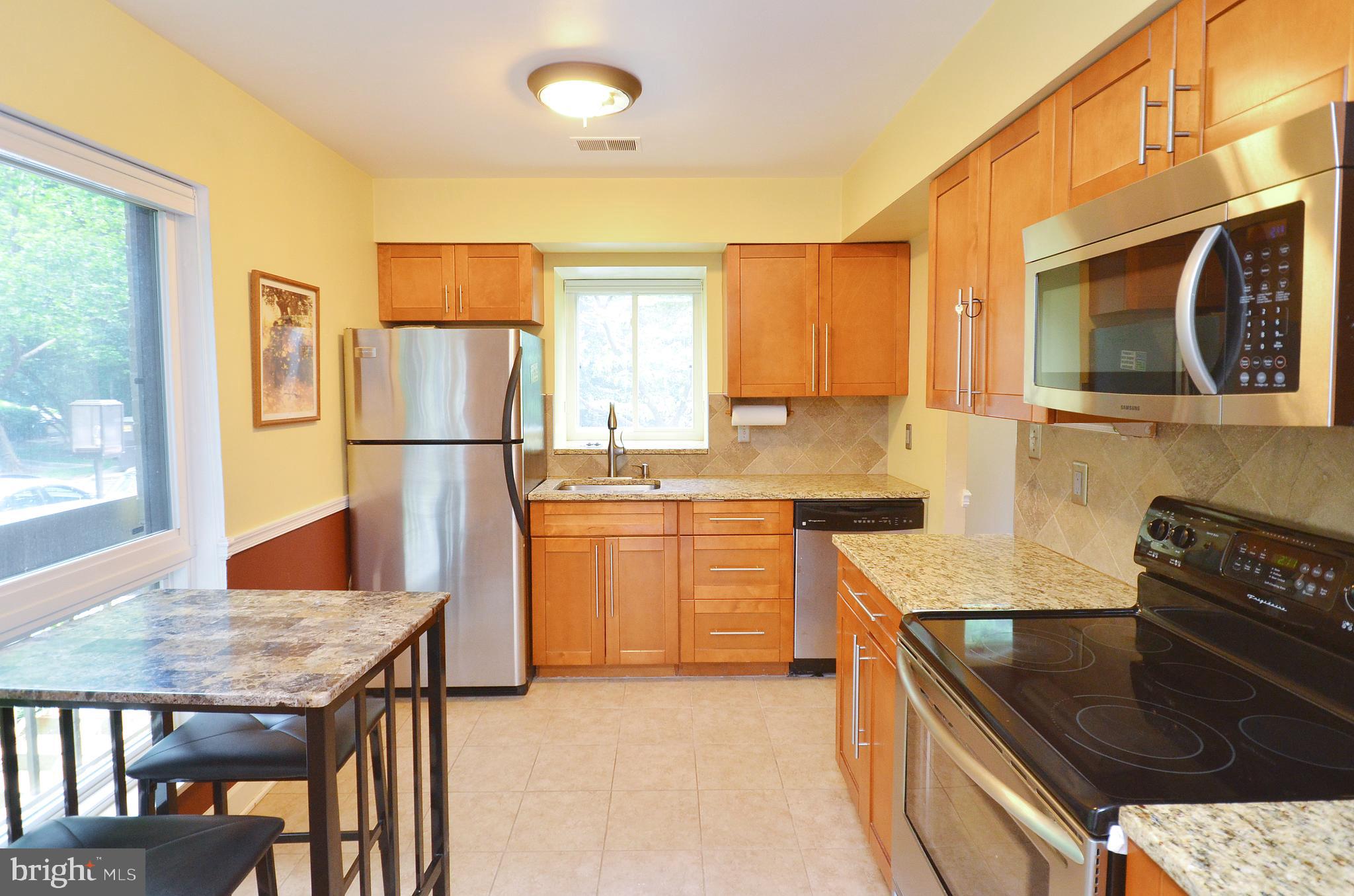 11214 Beaver Trail Court, Unit 12 Reston, VA 20191 - Photo 2 of 27 a kitchen with a stove a refrigerator and a stove top oven