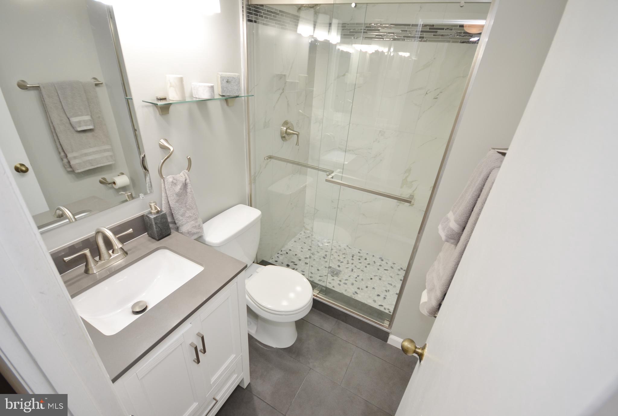 11214 Beaver Trail Court, Unit 12 Reston, VA 20191 - Photo 19 of 27 a bathroom with a granite countertop sink mirror vanity and toilet