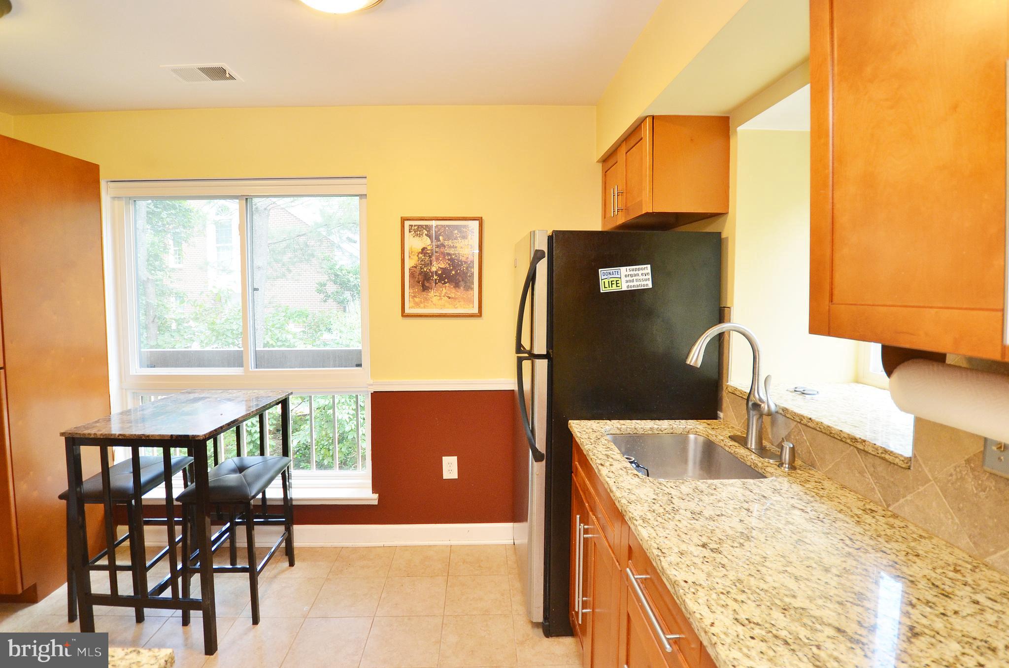 11214 Beaver Trail Court, Unit 12 Reston, VA 20191 - Photo 5 of 27 a kitchen that has a sink and a table in it