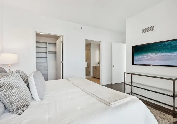 a bedroom with a large bed and a large window with outer view