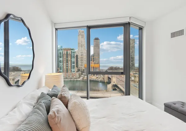 a bedroom with a large bed and a lamp