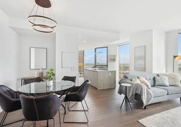 a large kitchen with kitchen island a large counter top space a sink a counter top space and living room view