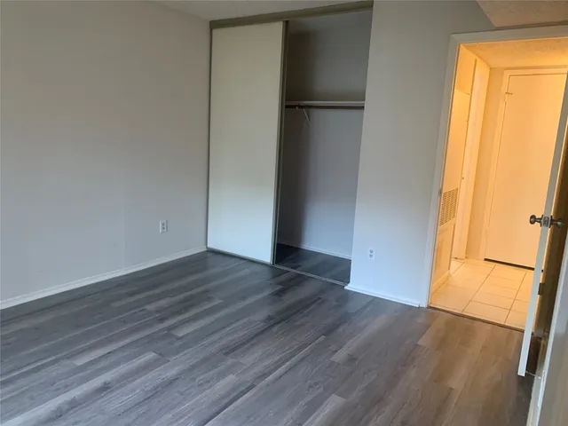 a view of empty room with wooden floor and window