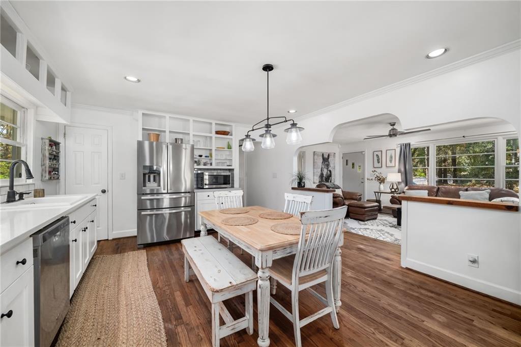 866 Buckner Road Mableton, GA 30126 - Photo 14 of 57 a kitchen with stainless steel appliances kitchen island granite countertop a dining table chairs and white cabinets
