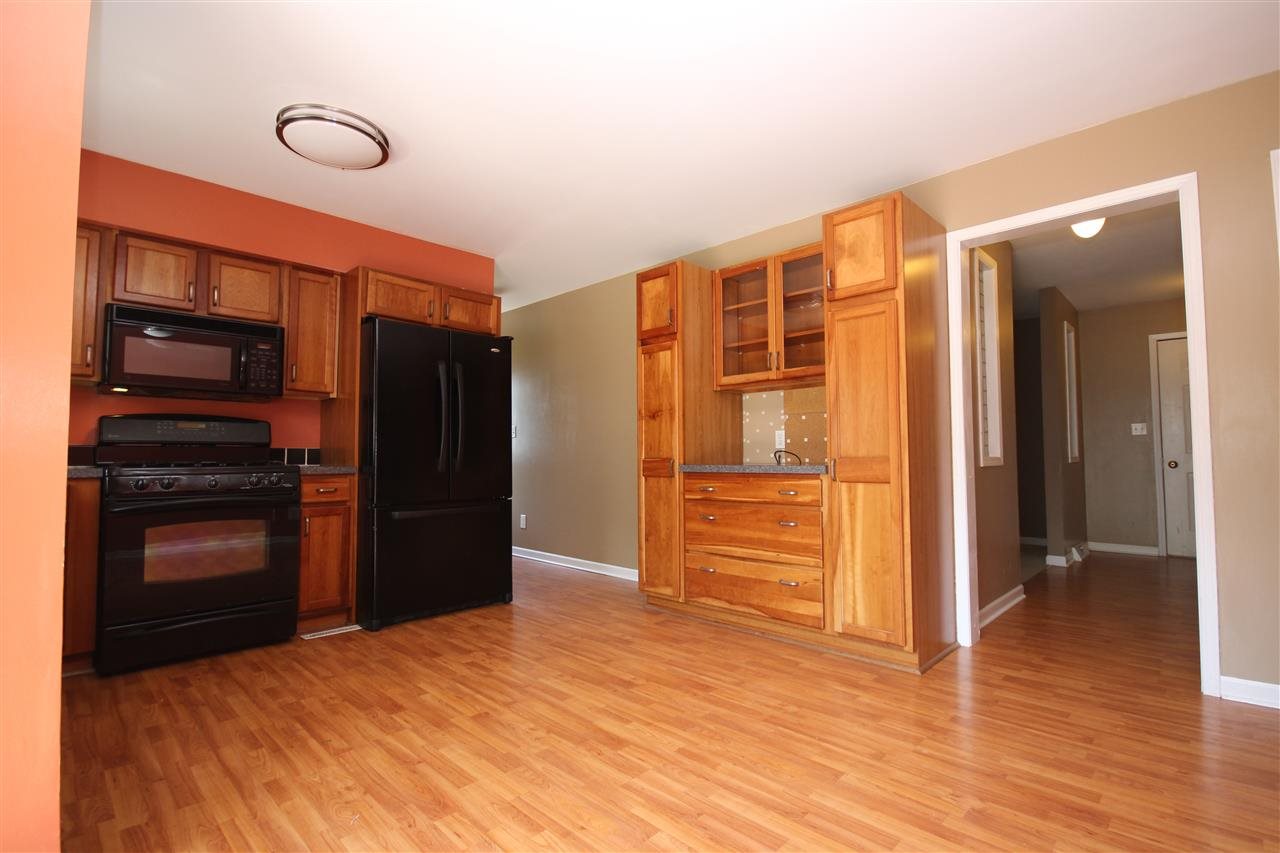 405 Pembroke Road Southwest Poplar Grove, IL 61065 - Photo 8 of 21 a view of a kitchen with wooden floor and a refrigerator