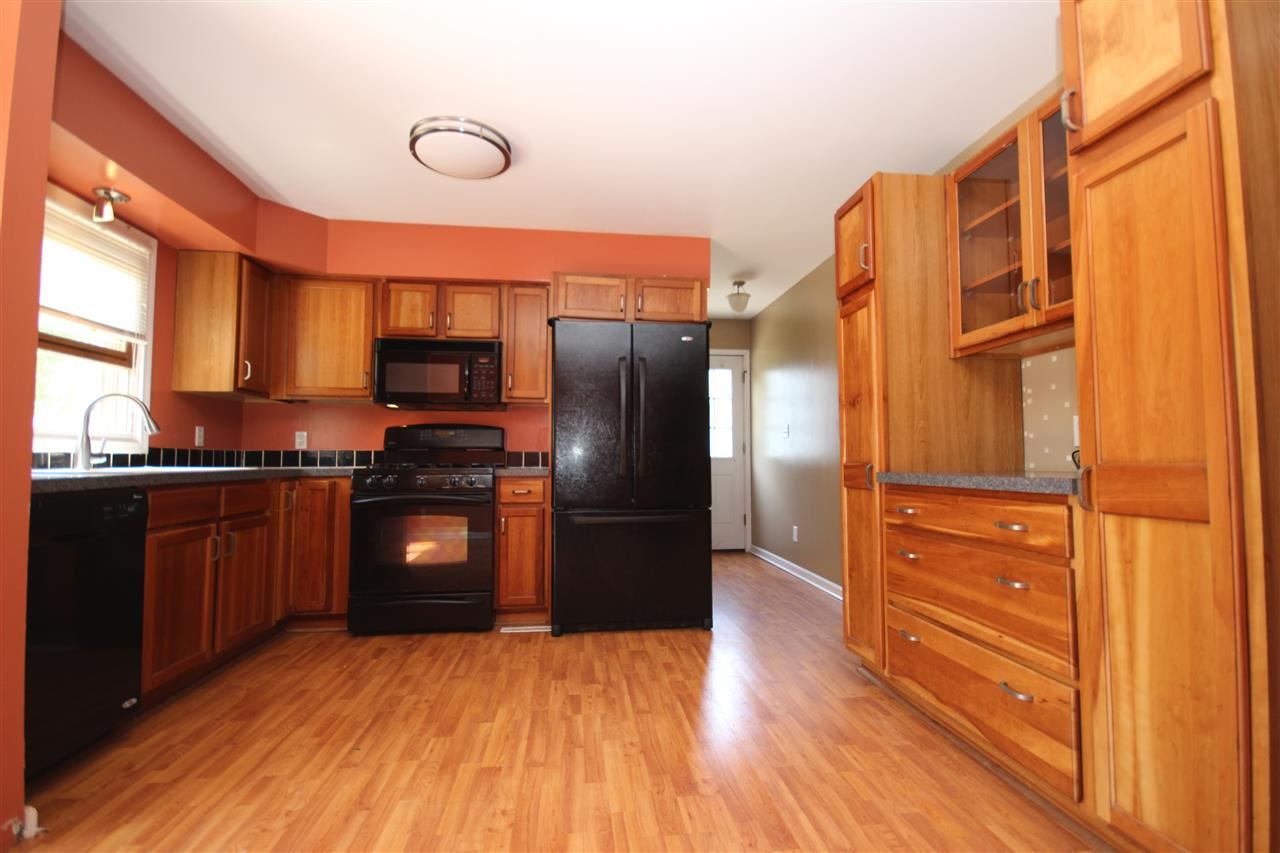 405 Pembroke Road Southwest Poplar Grove, IL 61065 - Photo 9 of 21 a kitchen with granite countertop stainless steel appliances and wooden cabinets