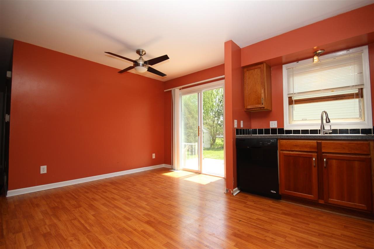 405 Pembroke Road Southwest Poplar Grove, IL 61065 - Photo 10 of 21 a kitchen with granite countertop a stove a sink and a refrigerator with wooden floor
