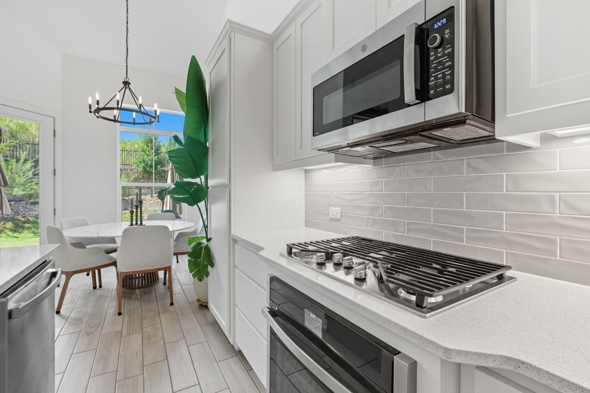 101 Cartwheel Bend, Unit 52 Austin, TX 78738 - Photo 11 of 31 a kitchen with a stove a microwave and wooden floor