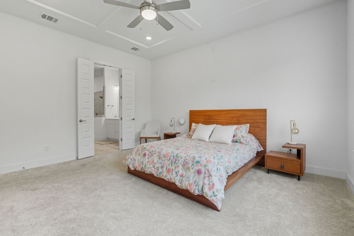 101 Cartwheel Bend, Unit 52 Austin, TX 78738 - Photo 14 of 31 a bedroom with a bed and a chandelier