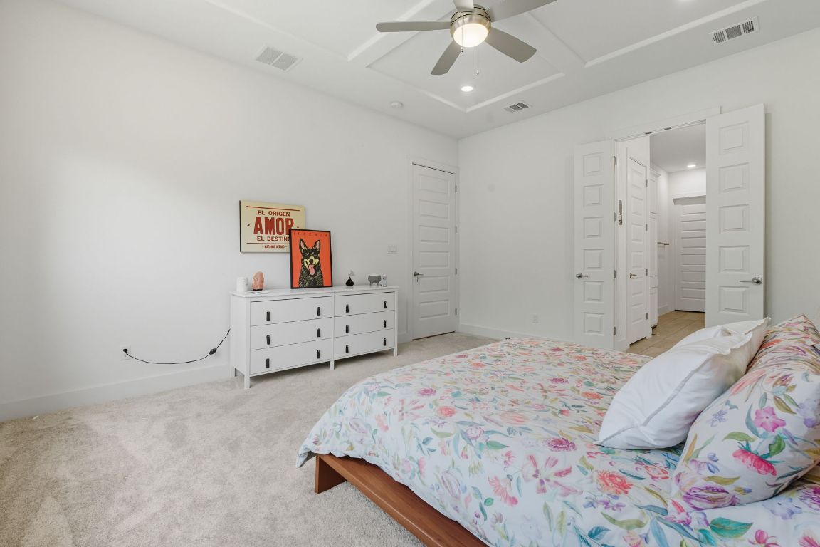 101 Cartwheel Bend, Unit 52 Austin, TX 78738 - Photo 15 of 31 a bedroom with a bed and a chandelier