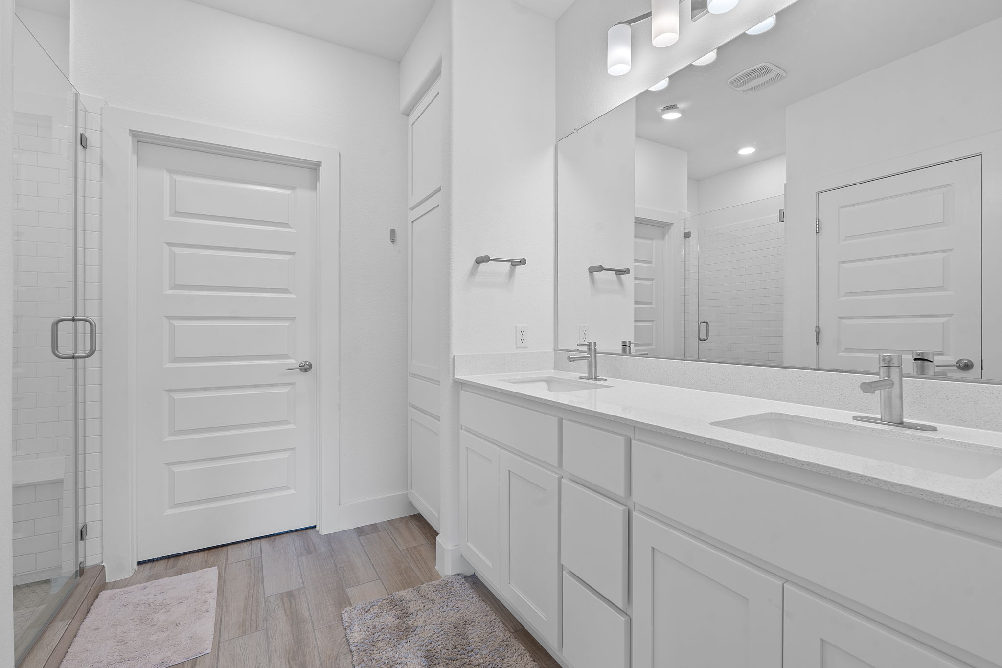 101 Cartwheel Bend, Unit 52 Austin, TX 78738 - Photo 21 of 29 a bathroom with a double vanity sink a mirror and a shower