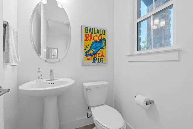 a bathroom with a toilet a sink and mirror