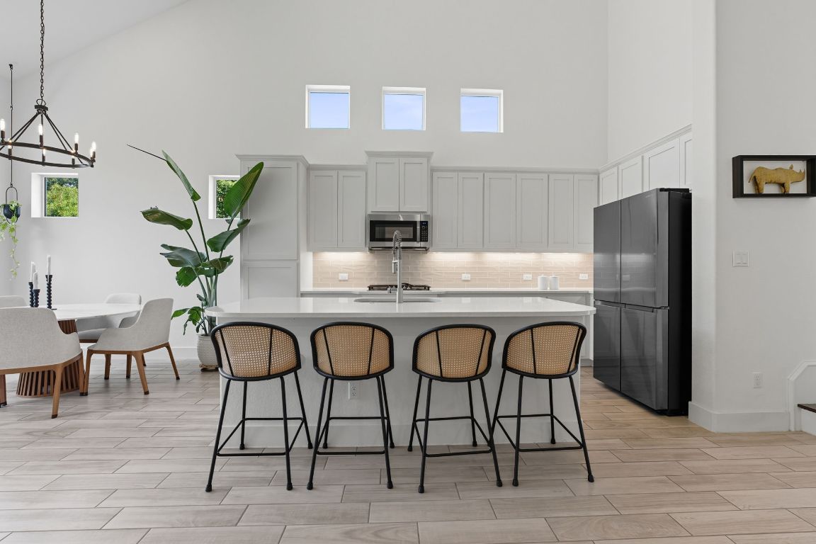 101 Cartwheel Bend, Unit 52 Austin, TX 78738 - Photo 7 of 31 a kitchen with stainless steel appliances granite countertop a table chairs stove and refrigerator