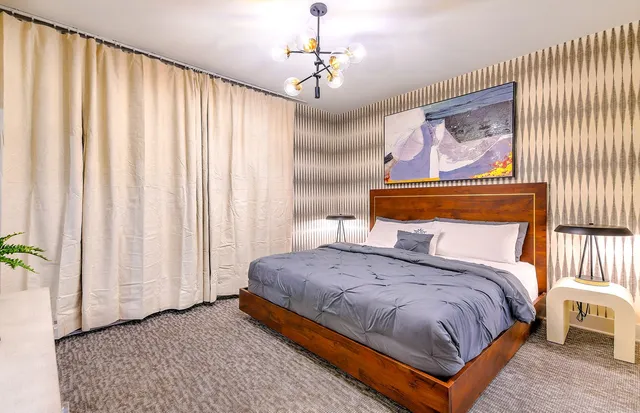 a bedroom with a bed and a painting on the wall