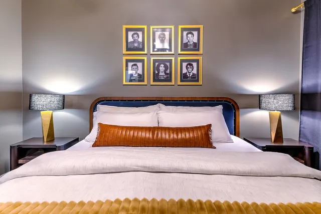 a bedroom with a bed and painting on the wall