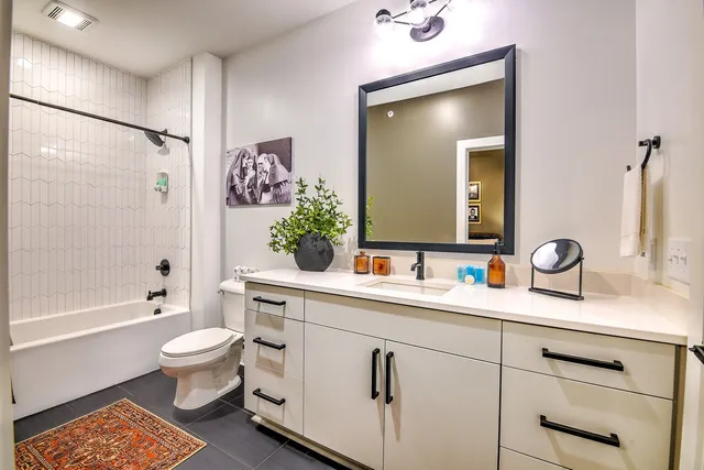a bathroom with a double vanity sink toilet mirror and shower