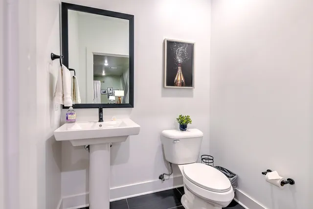 a bathroom with a toilet a sink and mirror