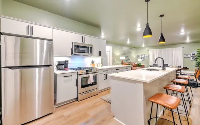 a kitchen with stainless steel appliances a stove a sink a refrigerator a center island and a refrigerator