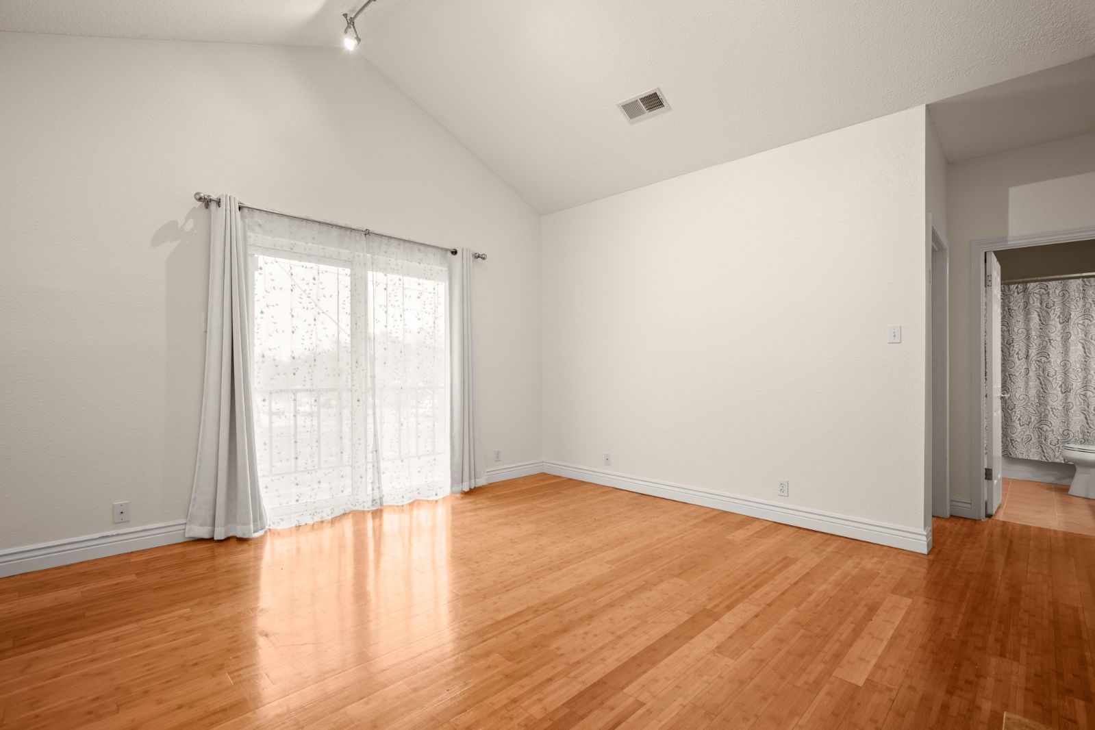 11970 Jollyville Road, Unit 216 Austin, TX 78759 - Photo 6 of 20 Empty room featuring light wood finished floors, track lighting, and lofted ceiling