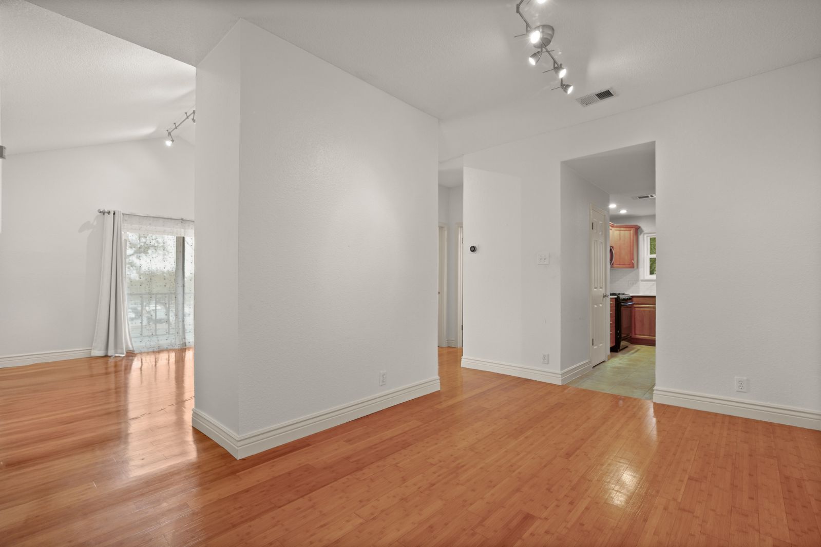 11970 Jollyville Road, Unit 216 Austin, TX 78759 - Photo 7 of 20 Spare room featuring rail lighting, light wood-style floors, and vaulted ceiling