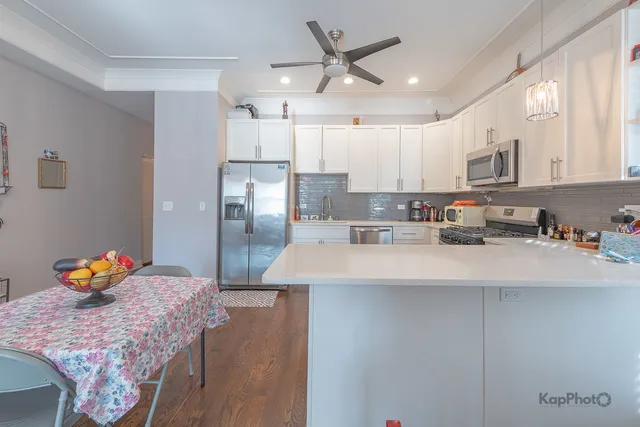 a kitchen with stainless steel appliances granite countertop a sink refrigerator and cabinets
