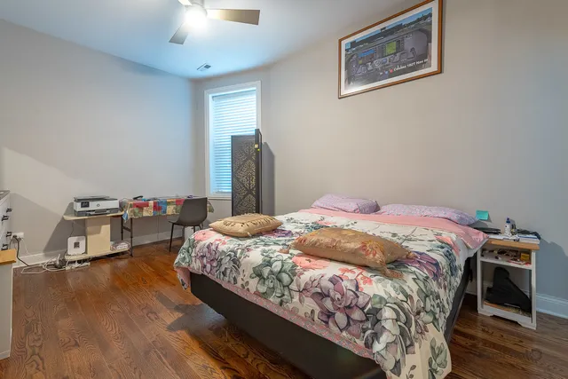a bedroom with bed and wooden floor